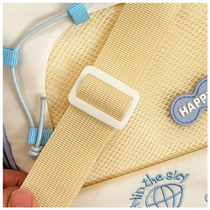 Detail of yellow mesh fabric and blue embroidery with happy text on casual shoulder bag