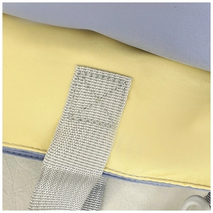 Macro shot of durable canvas stitching and gray strap on a blue and yellow tote bag