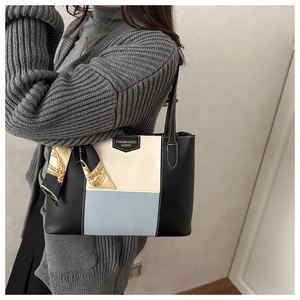 Detail view of tri-color tote bag with silk scarf accessory and gold hardware branding