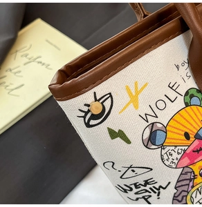 Détails rapprochés du sac en toile avec graffitis colorés et finitions en cuir