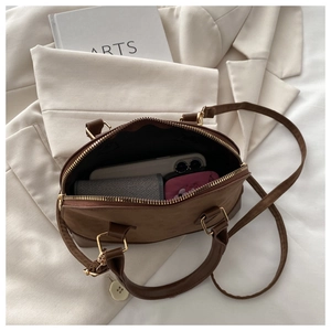 Interior view of brown suede shell bag showing storage for wallet and smartphone