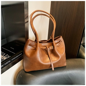 Detailansicht der braunen Ledertextur und Schnalle an der großen Vintage-Tote-Bag