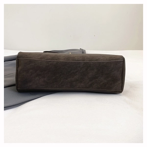 Detailed close-up showing reinforced stitching and matte vintage leather of the dark brown bag