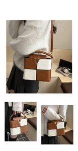 Detail der Patchwork-Eimertasche mit V-Metallschließe und eleganter Lychee-Struktur