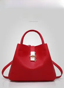 Front view of red pebbled leather bucket bag featuring a gold lock and chain detail