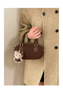 Detail of dark brown leopard texture Boston bag with Hello Kitty plush keychain