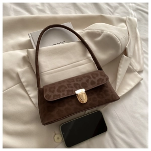 Détail du sac sous le bras à imprimé léopard avec boucle en métal doré et daim