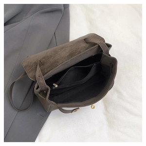 Detailed interior of gray suede tote bag showing zipper pocket and textured fabric