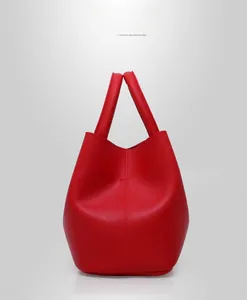 Detail of red bucket bag showing premium lychee grain faux leather and round handles