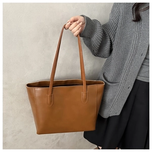 Classic tan large capacity tote bag shown being carried by a model for commuting