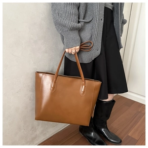 Brown leather tote bag showcased in a lifestyle setting with a stylish model