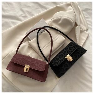 Detail view of burgundy and black leopard print baguette bags with gold metal clasps