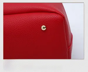 Detail of red lychee grain leather bottom corner with golden metal protective foot stud