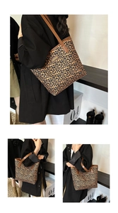 Close-up of leopard print tote bag with brown leather straps and gold fashion emblem