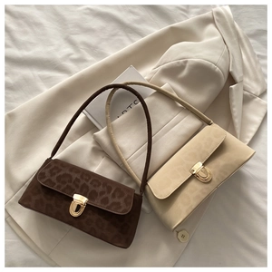 Close-up of leopard print baguette bags in brown and beige with gold metal buckles