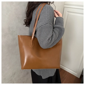 Grande borsa tote marrone caramello indossata da una modella per lo stile quotidiano