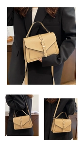 Detail of khaki leather crossbody bag with vintage gold buckle and top handle straps