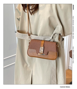 Close-up of brown saddle bag with woven texture, smooth leather and gold buckle
