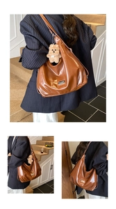 Detail of caramel brown tote bag with glossy finish and cute plush bear accessory