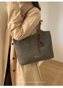 Detailed side view of large dark grey-green tote bag in soft faux suede with stitching