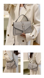 Detail of grey pebbled leather crossbody bag featuring adjustable strap and metal buckle