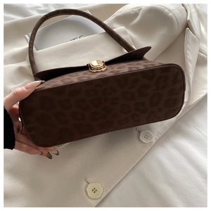 Close-up of leopard print shoulder bag with suede texture and gold twist lock detail