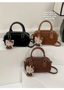 Vista dettagliata delle borse a bauletto nere e leopardate con ciondoli a gatto peluche