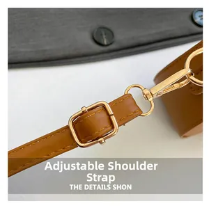 Macro detail of brown leather adjustable strap with polished gold-tone metal buckle