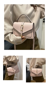 Detail of pink lychee leather handbag featuring a V-shaped flap and gold metal buckle