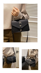 Detail view of black lychee leather handbag featuring gold horseshoe buckle and strap