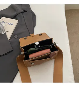Detailed interior of brown crossbody bag showing spacious compartments and magnetic closure