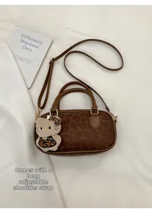 Dettaglio borsa leopardata con ciondolo a forma di gatto in peluche e tracolla regolabile