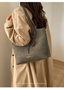 Vue détaillée d'un grand cabas en cuir vert olive porté avec un trench-coat beige élégant