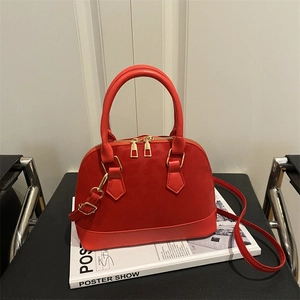 Sac à main rouge en cuir au design élégant avec bandoulière et détails dorés brillants