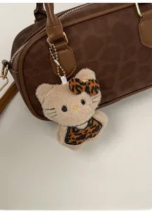 Dettaglio del ciondolo a gatto in peluche con fiocco leopardato su borsa in pelle