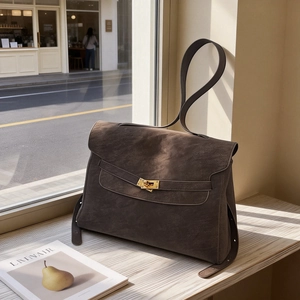 Brown matte suede large capacity shoulder bag with gold twist lock on sunny window