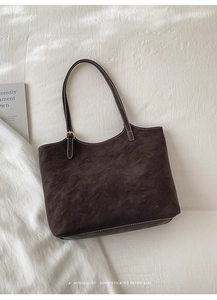 Gros plan détaillé du sac cabas mat marron foncé avec détails de boucles dorées