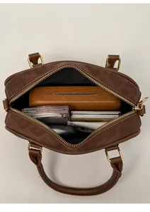 Inside view of a brown suede pillow bag filled with daily items showing large capacity