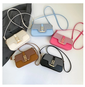 Detailed flat lay of five saddle bags in multiple colors with golden greek key buckles