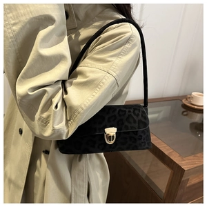 Chic black leopard print baguette bag with gold buckle worn on a beige trench coat