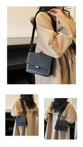 Detail view of black square crossbody bag featuring wide strap and fashion lettering