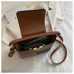 Detail der Patchwork-Beuteltasche mit Innenraum und goldener V-förmiger Metallschnalle