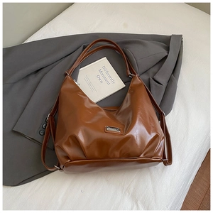 Detailed close-up of brown PU leather texture and metal logo on a vintage tote bag