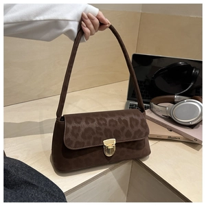 Detail of brown leopard print suede shoulder bag featuring a gold metallic clasp buckle
