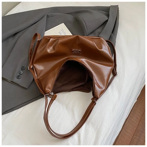 Detail shot of vintage dark brown faux leather tote with metallic logo and zipper