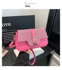 Detail of pink shoulder bag featuring red striped flap and gold rectangular buckle