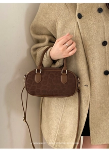 Dettaglio della borsa a bauletto leopardata con hardware dorato e texture scamosciata