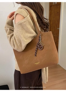 Gros plan sur le cabas en cuir mat marron avec un pendentif boulier décoratif