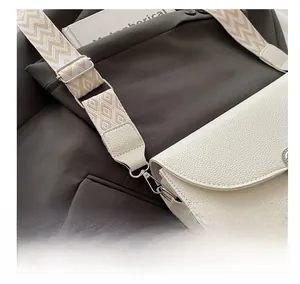 Dettaglio borsa in pelle avorio con tracolla intrecciata bohémien e gancio in metallo