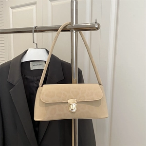 Elegant beige underarm bag with leopard print flap and gold clasp on a display rack
